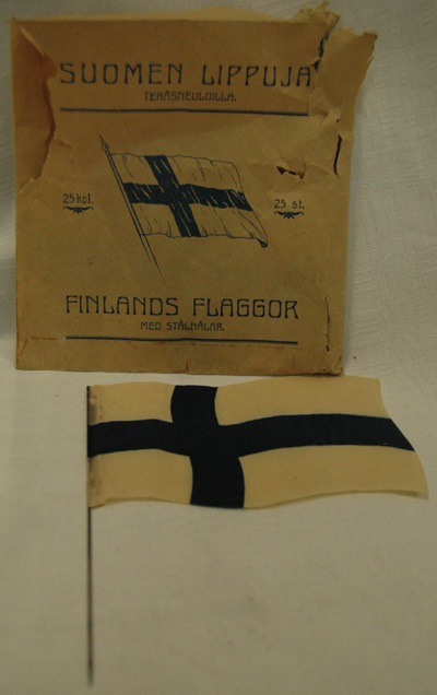 10827 Suomen lippuja teräsneuloilla pakkauksessaan
